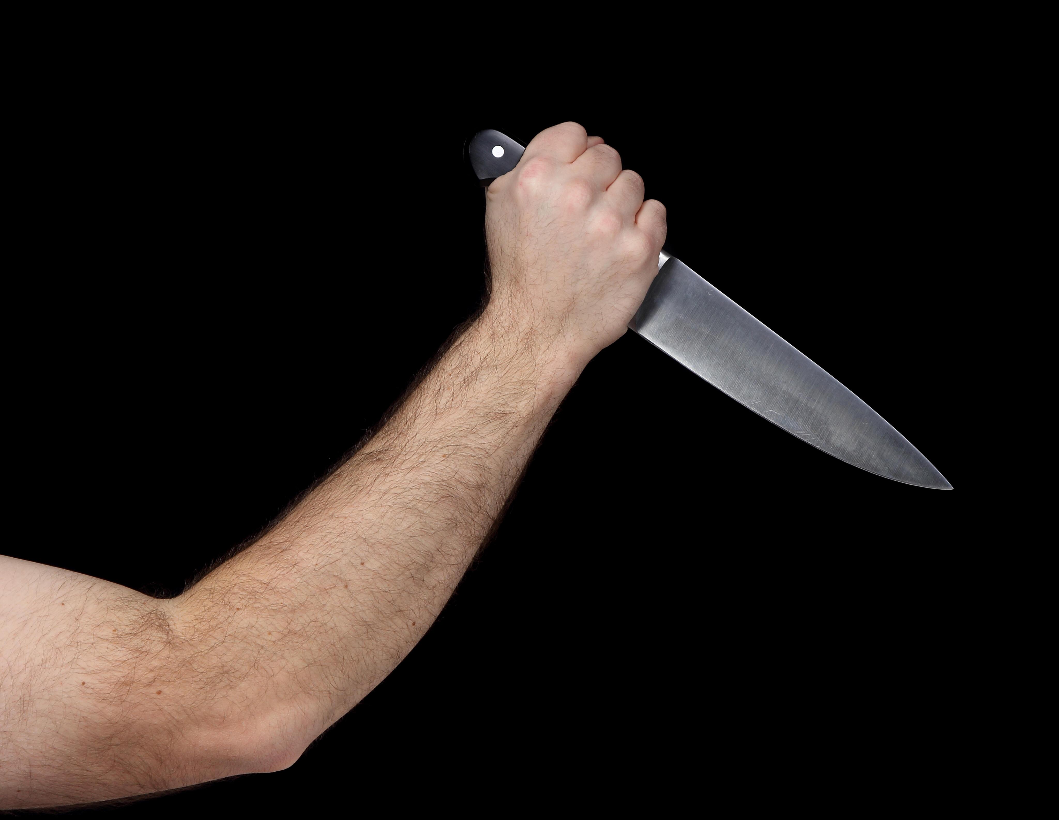 Колет ножом. Рука держит нож.